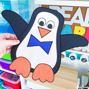 May include: A black and white penguin with orange feet and a blue bow tie. The penguin is holding out its wings and has large, white eyes.