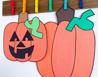 May include: Three paper pumpkins hanging from clothespins on a wooden board. The pumpkins are orange and have black facial features. One pumpkin has a green leaf.
