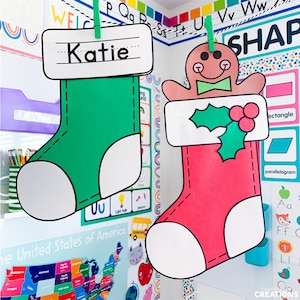 May include: Two Christmas stockings hanging on a string. One stocking is green with the name "Katie" written on it. The other stocking is red with a gingerbread man on it.
