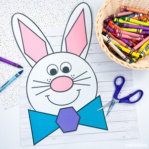 May include: A printable Easter bunny craft template with a white bunny face, pink ears, a blue bow tie, and a purple bow tie center. The bunny has black eyes, a pink nose, and a black mouth. The template is on a white background with a woodgrain pattern.