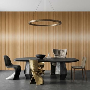 May include: A black dining table with a thick, irregular top and two geometric, dark gray bases. The table is surrounded by four chairs: one black cantilever chair, one gold twisted metal chair, one beige upholstered chair, and one clear acrylic chair.
