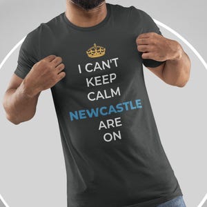 May include: A black t-shirt with a white graphic that says "I can't keep calm Newcastle are on" with a gold crown above the text.