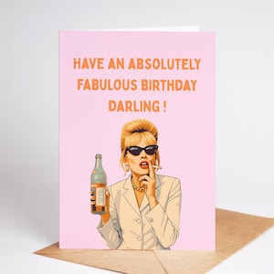 May include: A pink birthday card with the text "HAVE AN ABSOLUTELY FABULOUS BIRTHDAY DARLING!". The card features an illustration of a woman in sunglasses holding a bottle and smoking a cigarette.