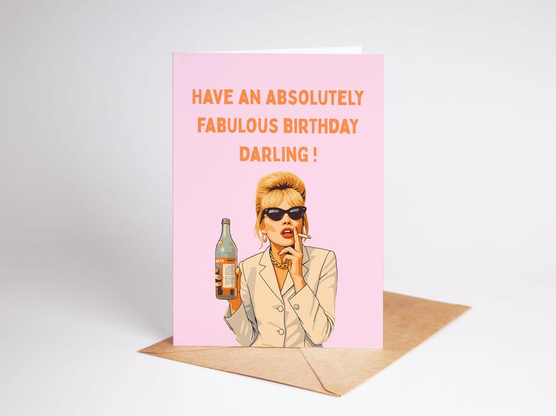 May include: A pink birthday card with the text "HAVE AN ABSOLUTELY FABULOUS BIRTHDAY DARLING!". The card features an illustration of a woman in sunglasses holding a bottle and smoking a cigarette.