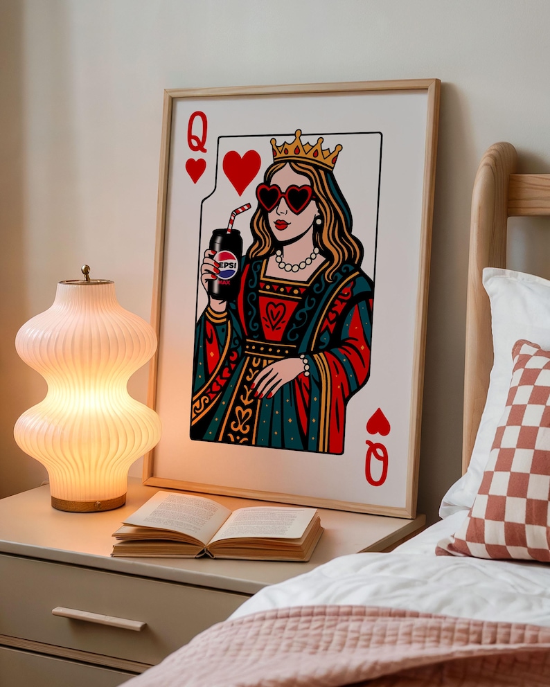 May include: A framed art print of a playing card, the Queen of Hearts, holding a Pepsi can. The queen wears heart-shaped sunglasses and a crown. The artwork is in a retro style with red, blue, and gold colors.