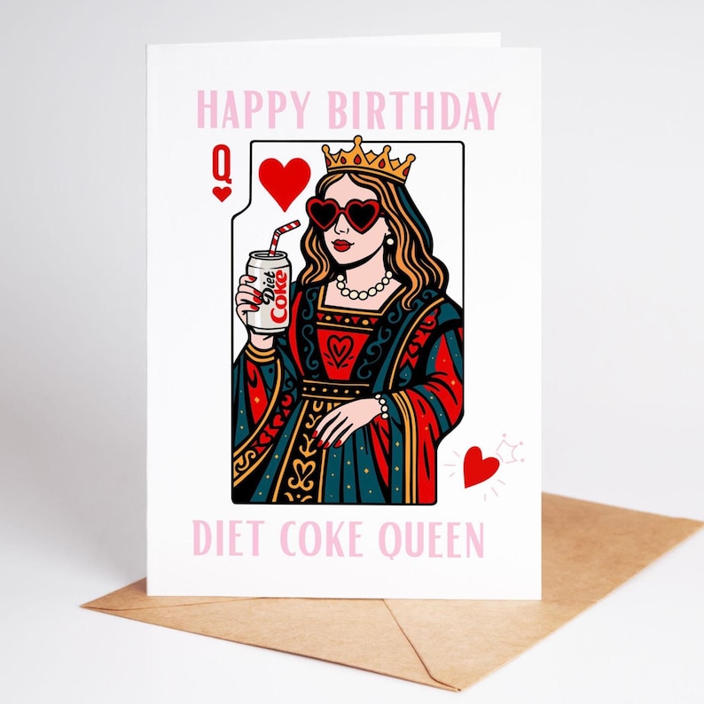 May include: A greeting card with a cartoon illustration of a queen holding a Diet Coke can. The queen wears heart-shaped sunglasses and a crown. The card reads "Happy Birthday" and "Diet Coke Queen" in pink text.