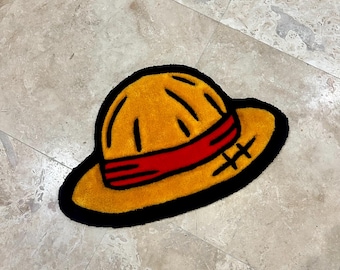 May include: A yellow straw hat with a red band and black stitching. The hat is on a light brown tiled floor.