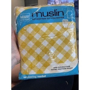 May include: A package of a Montgomery Ward Style House double size fitted bottom sheet in a yellow and white gingham check pattern. The packaging is made of clear plastic and features the text muslin, 50% cotton 50% polyester, and no ironing needed.