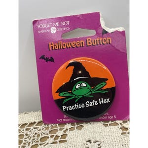 Puede incluir: Un botón de Halloween con una rana verde con un sombrero de bruja negro, sobre un fondo naranja y negro. El botón dice "Practice Safe Hex" y está en una tarjeta morada con "Halloween Button".