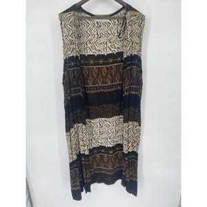 May include: A sleeveless dress with a patchwork design. The dress features alternating stripes of zebra print, brown leaf patterns, and solid black and brown sections. The dress is hanging on a wooden hanger against a white background.