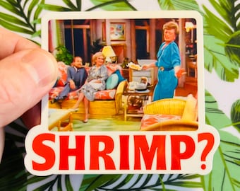 May include: A rectangular sticker featuring a scene from a television show with three people on a couch and a woman in a blue dress. The sticker has the word "SHRIMP?" in red letters.