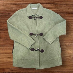 May include: A light green toggle coat with a collared neckline and long sleeves. The coat features three dark brown leather and silver toggle closures down the front. The coat is made of a textured knit fabric.