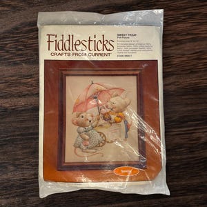 May include: A cross-stitch kit featuring a sweet treat scene with two mice. The mouse on the left is holding an umbrella and the mouse on the right is selling ice cream. The kit includes 100% polyester fabric, 100% cotton backing fabric, 100% polyester thread, a needle, and instructions. The finished size is 8 by 10 inches. The kit is from Fiddlesticks Crafts from Current and the code is 9400-7.