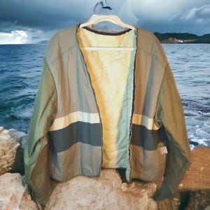 May include: A multi-colored jacket with a zipper closure. The jacket is made of a lightweight fabric and has a striped pattern in shades of green, blue, and white.