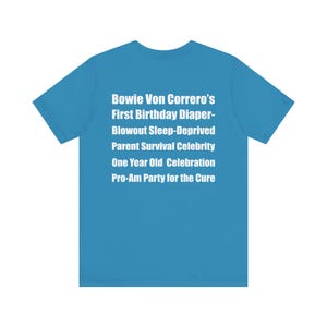 Op de afbeelding: Een turquoise t-shirt met witte tekst. De tekst luidt: "Bowie Von Correro's First Birthday Diaper-Blowout Sleep-Deprived Parent Survival Celebrity One Year Old Celebration Pro-Am Party for the Cure."