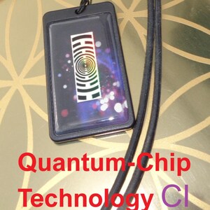 May include: Black rectangular amulet with a clear front, featuring a colorful geometric design. The amulet is attached to a black cord. Text on the image reads "AKASHA-LIFE AMULETT" and "Quantum-Chip Technology".