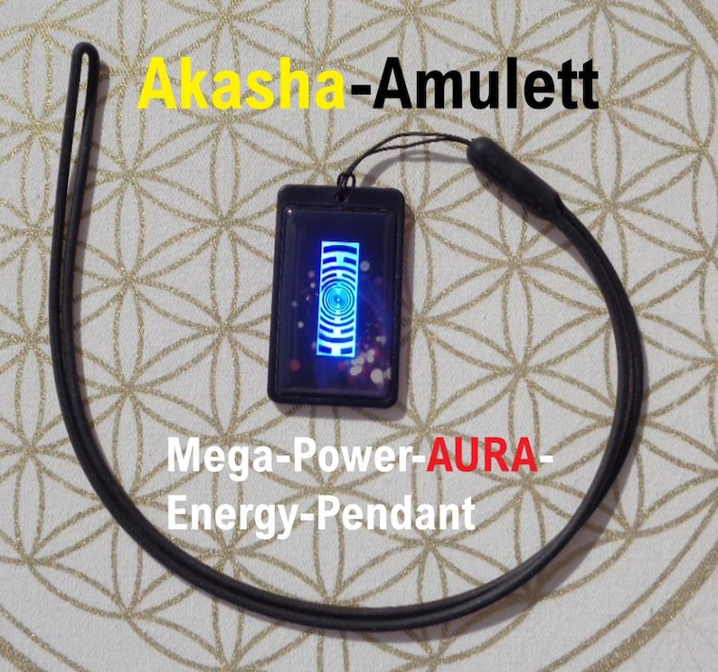 May include: Black rectangular pendant with a blue and white design, attached to a black cord. The pendant has the text "Akasha-Amulett" in yellow and "Mega-Power-AURA-Energy-Pendant" in white and red.