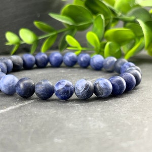 May include: A blue gemstone bracelet with round beads. The bracelet is made of natural stones and is a popular choice for meditation and healing.