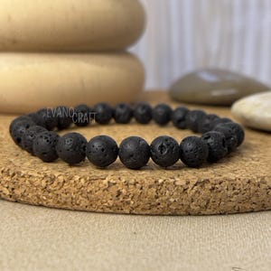 Peut inclure: Bracelet en perles de roche volcanique noire. Le bracelet est composé de petites perles rondes à la surface rugueuse et texturée.
