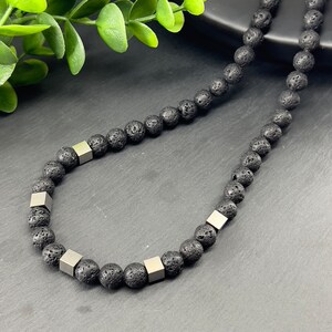 May include: A black lava rock beaded necklace with silver square beads.