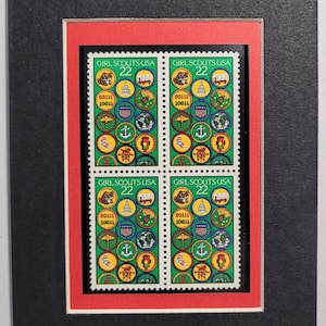 May include: Four green and white Girl Scout USA stamps with the year 22 printed on each. Each stamp features a variety of Girl Scout badges and symbols.