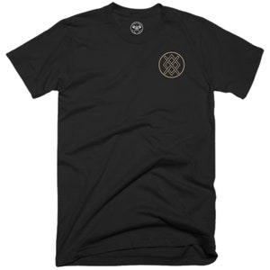 May include: Black t-shirt with a small, circular, gold-coloured logo on the left chest. The logo features a geometric design with intersecting lines.