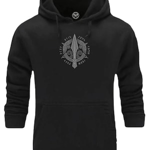 Könnte beinhalten: Schwarzer Kapuzenpullover mit einem weißen Grafikdruck einer Lanze mit zwei Raben und Runen, die sie umgeben. Die Runen lauten "Fylgja", "Hvítr", "Teitr", "Mör", "Rípa", "Kýnn", "Hnís", "Tæm", "Fyr", "Mæðr".