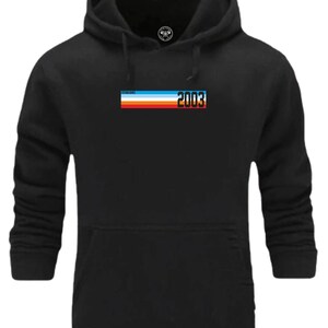 Könnte beinhalten: Schwarzer Kapuzenpullover mit einem weißen, blauen, roten und orangenen Streifen über der Brust und dem Text "Gegründet 2003".