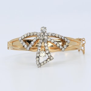 May include: A white ceramic mug with a black handle and the text "But First, Coffee" in a bold, black font. The mug is set against a blurred background, suggesting a cozy setting.