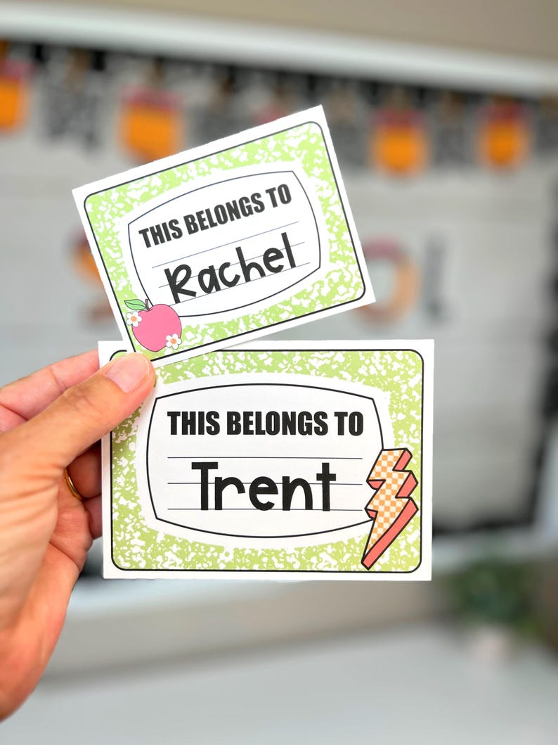 May include: Two rectangular name tags with a notebook paper design. The top tag reads "THIS BELONGS TO Rachel" with an apple graphic. The bottom tag reads "THIS BELONGS TO Trent" with a lightning bolt graphic. Both tags have a green border.