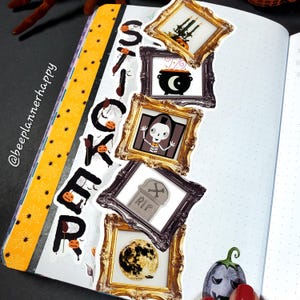 May include: A journal spread with Halloween-themed stickers. The word "STICKER" is spelled out vertically with individual letter stickers. Decorative stickers include framed images of a cauldron, skeleton, tombstone, and full moon. The journal has a yellow and black border.