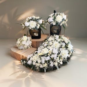 Könnte beinhalten: Weiße Blumenarrangements in verschiedenen Größen und Formen, die auf Holzplattformen präsentiert werden. Die Blumen sind in einer kaskadierenden Anordnung angeordnet, wobei das größte Arrangement in der Mitte liegt.
