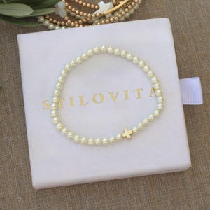 May include: A white ceramic mug with a black handle and the text "But First, Coffee" in a handwritten style. The mug is on a white surface. The mug is 10 cm tall.