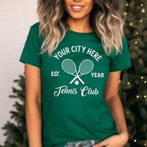 May include: A green t-shirt with a white tennis racket design and the text "Your City Here Est. Year Tennis Club".