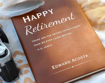 Può includere: Un diario rilegato in pelle marrone con le parole "HAPPY Retirement" in lettere bianche. La citazione "THERE ARE FAR BETTER THINGS AHEAD THAN WE EVER LEAVE BEHIND. -C.S. LEWIS" è stampata sotto il titolo. Il nome "EDWARD ACOSTA" è stampato in fondo al diario.