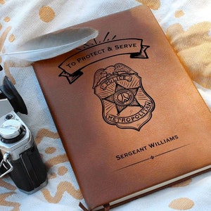 May include: A brown leather journal with a police badge design and the text "To Protect & Serve" and "Sergeant Williams".