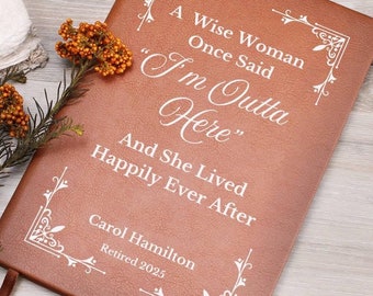 Può includere: Un diario rilegato in pelle marrone con una scritta bianca che dice "A Wise Woman Once Said "I'm Outta Here" And She Lived Happily Ever After" e "Carol Hamilton Retired 2025".