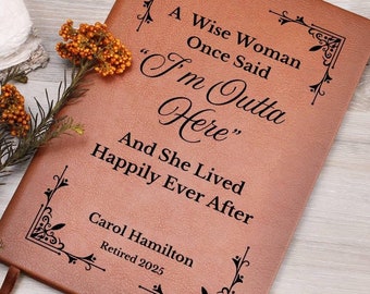 Può includere: Un diario in pelle marrone con il testo "A Wise Woman Once Said "I'm Outta Here" And She Lived Happily Ever After" e il nome "Carol Hamilton Retired 2025" inciso sulla copertina.