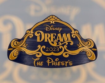 Può includere: Un ornamento blu e oro Disney Dream 2023 con il testo "The Priest's" in basso.