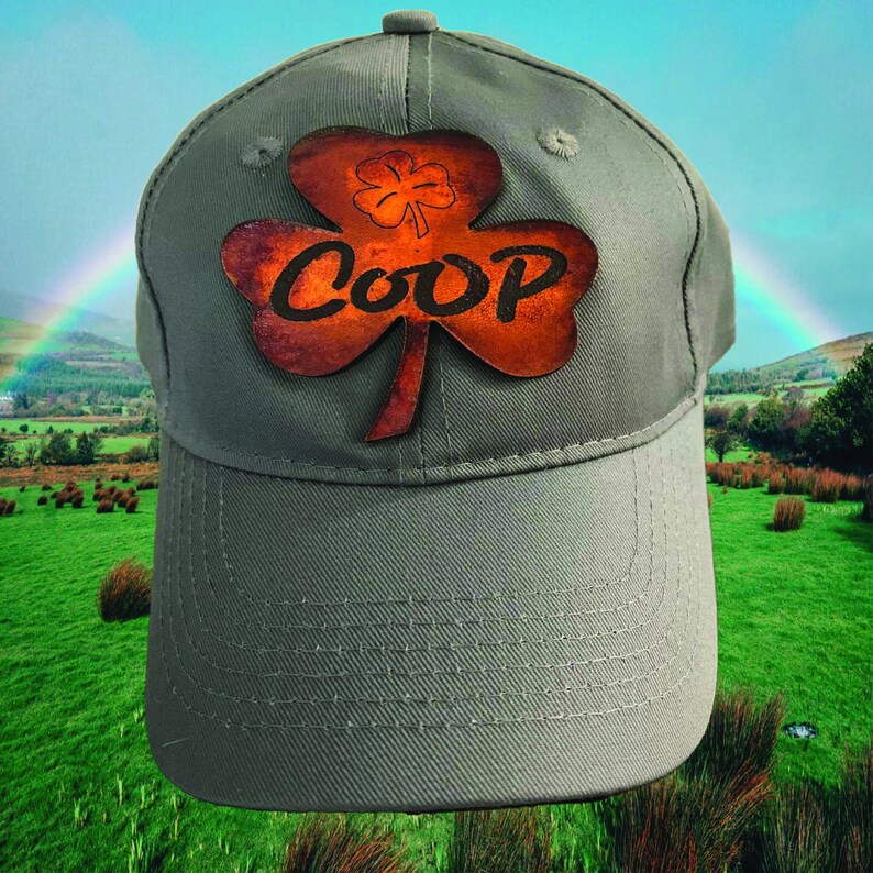 May include: A green baseball cap with a brown leather shamrock patch that says "COOP" in a stylized font.