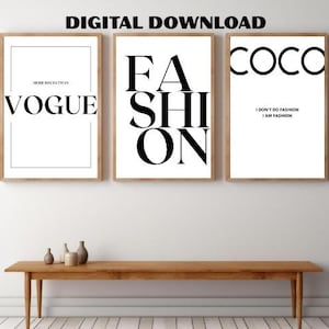 以下が含まれることがあります： 木製のフレームに入った3つのアートプリント。プリントは、白い背景に太字の黒いテキストが特徴です。テキストには「VOGUE」、「FASHION」、および「COCO」が含まれています。Cocoプリントには「I DON'T DO FASHION I AM FASHION」というテキストが含まれています。