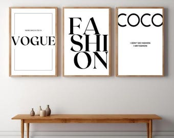 Puede incluir: Tres impresiones artísticas enmarcadas con marcos de madera. Las impresiones presentan texto negro en negrita sobre un fondo blanco. El texto incluye "VOGUE", "FASHION" y "COCO", con la cita "I DON'T DO FASHION I AM FASHION".