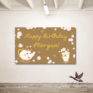 May include: A brown banner with gold text reading "Happy Birthday Morgan!". The design includes illustrations of a teapot and teacup, with star and bubble details. The banner is suitable for a birthday party.