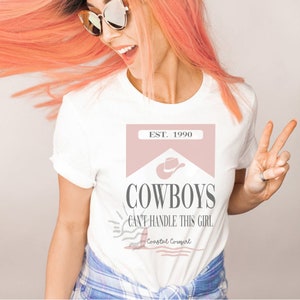 K&ouml;nnte beinhalten: Wei&szlig;es T-Shirt mit einer pinkfarbenen Grafik, auf der "EST. 1990 COWBOYS CAN'T HANDLE THIS GIRL Coastal Cowgirl" steht.