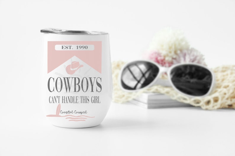 K&ouml;nnte beinhalten: Ein wei&szlig;er Edelstahl-Weinglas mit einem rosa und grauen Design. Das Design zeigt einen Cowboyhut und den Text "EST. 1990 COWBOYS CAN'T HANDLE THIS GIRL Coastal Cowgirl".