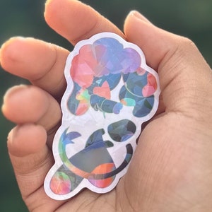 May include: A sticker featuring a colorful, abstract design of a creature with a flower in its mouth. The creature is outlined in black and has a white background.