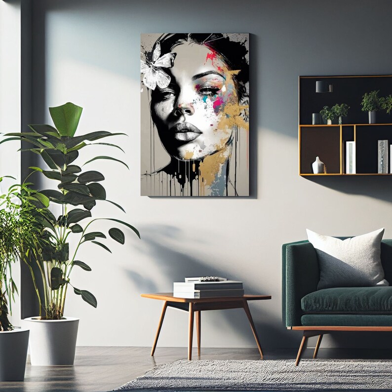 May include: Abstract portrait art print of a woman's face with a butterfly in her hair. The artwork features a grayscale face with colorful paint splatters in pink, blue, and gold. Black paint drips down from the bottom of the canvas.