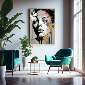 May include: A framed art print featuring a black and white portrait of a woman with colorful abstract paint accents. A white butterfly adorns her hair. The artwork hangs above a teal sofa and chair in a modern living room setting.