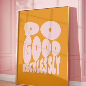Puede incluir: Una impresión enmarcada con fondo amarillo y texto rosa que dice "Do Good Recklessly".