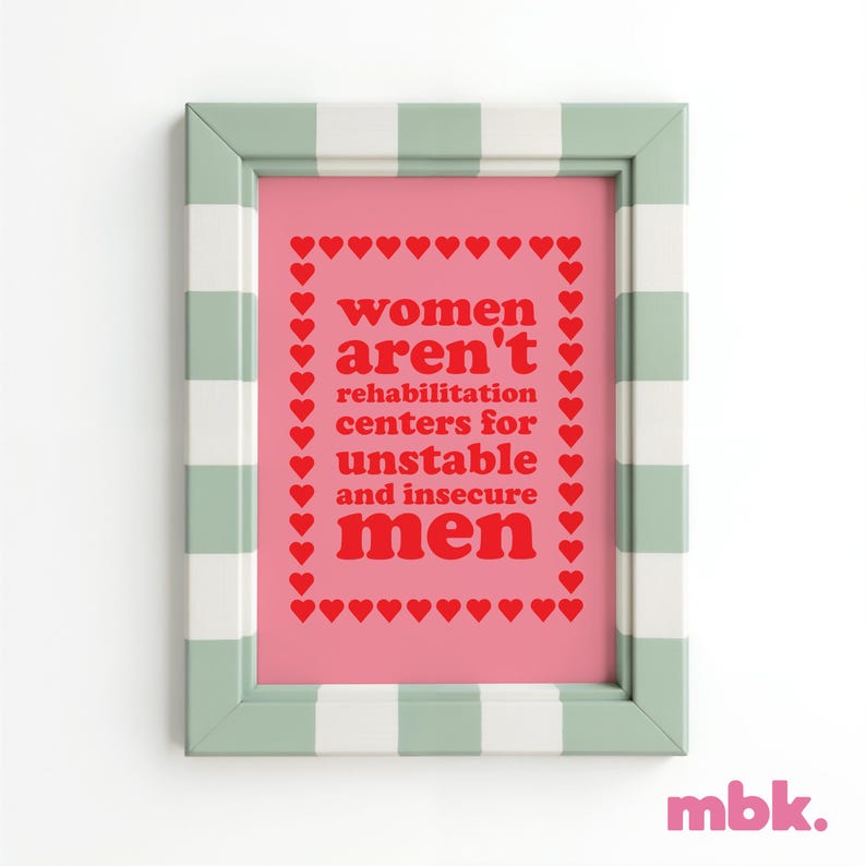 May include: A framed print with a pink background and a white and green checkered frame. The print features the text "women aren't rehabilitation centers for unstable and insecure men" in red letters surrounded by a border of red hearts.